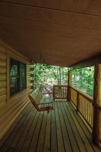 a porch of a cabin with a bench on it at Timber Ridge - by The Chalets in South Bloomingville