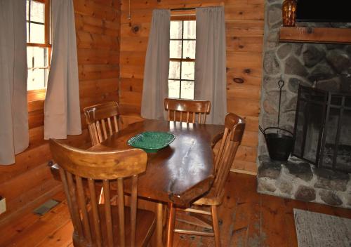 a dining room with a table and chairs and a fireplace at Timber Ridge - by The Chalets in South Bloomingville