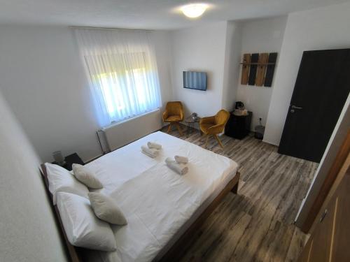 a bedroom with a white bed and a table and chairs at House Mila in Korenica