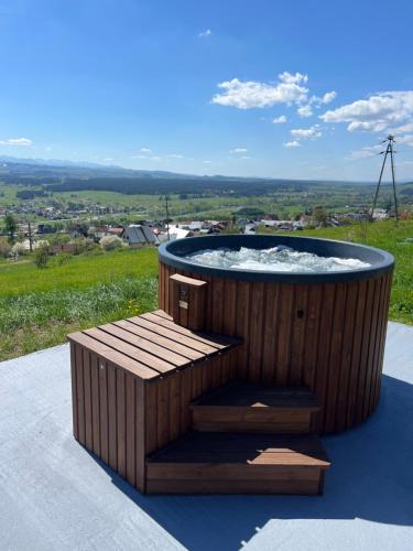 a wooden hot tub with a wooden bench around it at Czarne Ptaszki in Szlembark