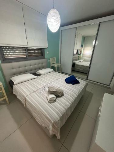 a bedroom with a large bed with a hat on it at רויאל פארק פרימיום in Eilat