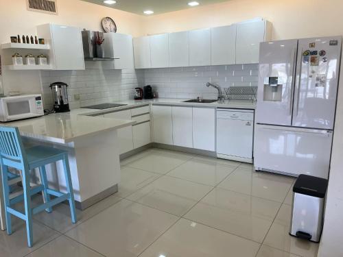 a kitchen with white cabinets and a white refrigerator at רויאל פארק פרימיום in Eilat