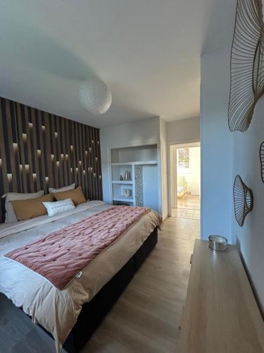 a bedroom with a large bed and a wooden floor at Home Lyla in Dijon