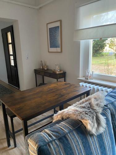 a living room with a wooden table and a couch at Das Garden House - Hohensee Erdgeschoss in Zemitz