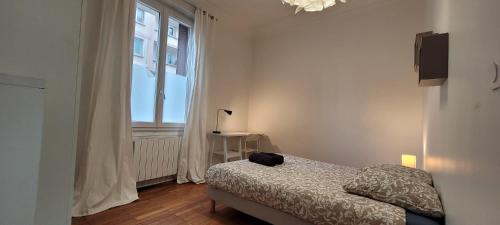 une chambre avec un lit et une grande fenêtre dans l'établissement Le Foch - 3 Chambres-proche centre, à Grenoble