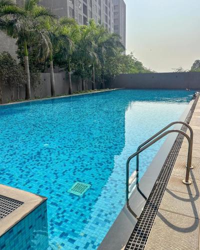 a large swimming pool with blue water and palm trees at Weekend Address in Dumas
