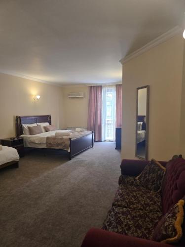 a hotel room with a bed and a couch at Ritsa Boutique Hotel in Batumi