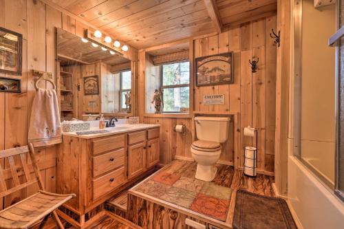 a log cabin bathroom with a toilet and a sink at Trout Lodge at Two Rivers-White River Cabin in Norfork