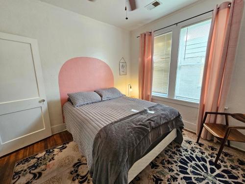 a bedroom with a bed with a pink headboard at Cool and calm place to live in Memphis