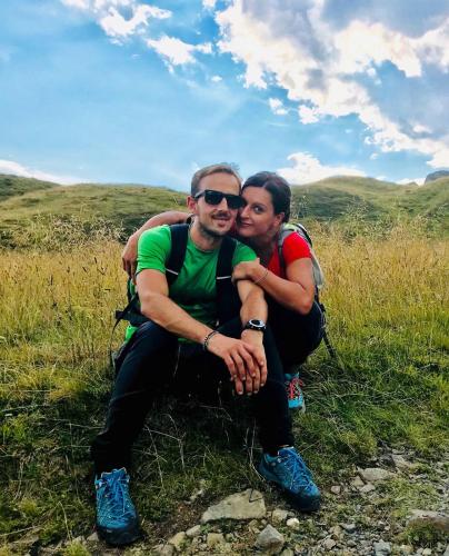two men are sitting on a grassy hill at A cjase di Diego in Paluzza