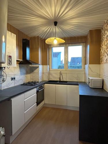 une cuisine avec des placards blancs et un plafond dans l'établissement Home Lyla, à Dijon