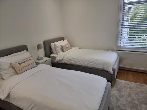 a bedroom with two beds and a window at Bright East Dulwich Apartment in London