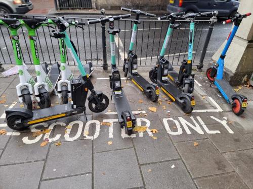a row of scooters parked next to a fence at Bright East Dulwich Apartment in London