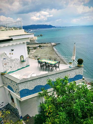 a balcony with a table and chairs next to the water at MAR-ISA Amalfi Coast in Vietri sul Mare