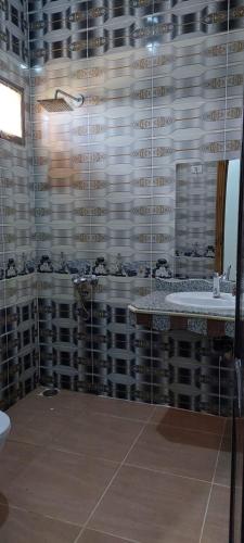 a bathroom with a sink and a glass wall at Green Beach Camp & Hotel in Nuweiba