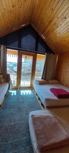 a bedroom with two beds in a room with a window at Green Beach Camp & Hotel in Nuweiba