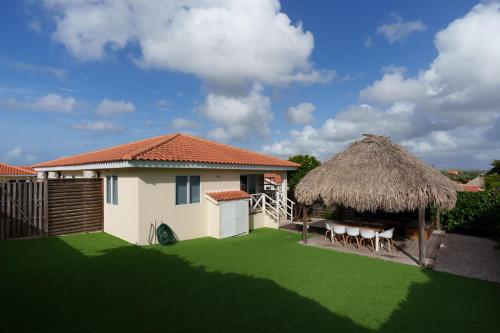 ein kleines Haus mit Grasdach in der Unterkunft Family Home Jan Thiel op Marbella in Willemstad