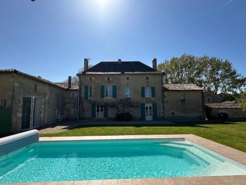 une grande piscine devant une maison dans l'établissement Domaine Belotterie, Rural French Retreat, Sleeps 15 plus, Pool & Orchard, à Château-Garnier
