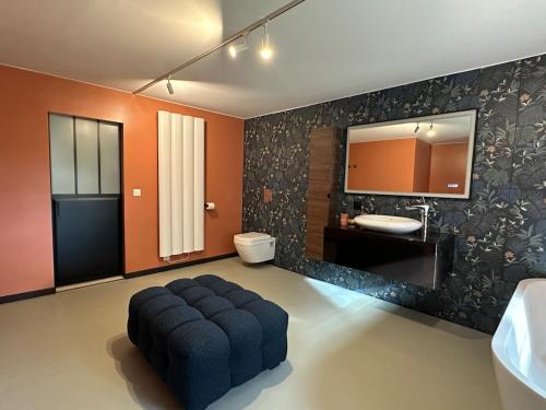 une salle de bain avec un pouf au milieu d'une pièce dans l'établissement Domaine Belotterie, Rural French Retreat, Sleeps 15 plus, Pool & Orchard, à Château-Garnier