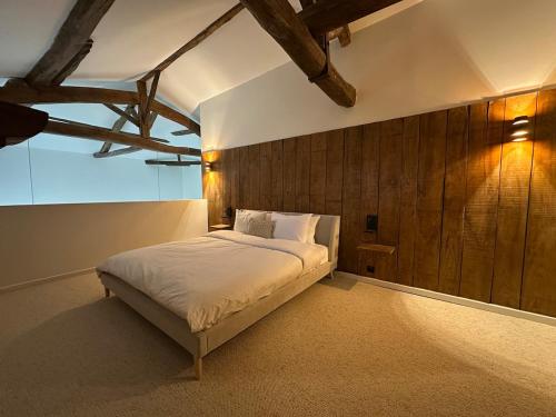 - une chambre avec un lit et un mur en bois dans l'établissement Domaine Belotterie, Rural French Retreat, Sleeps 15 plus, Pool & Orchard, à Château-Garnier