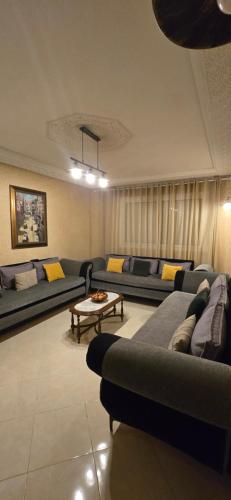 a living room with couches and a coffee table at Résidence achakkar hill in Jbila