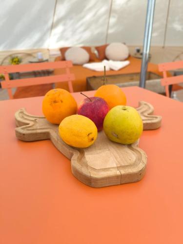 un bouquet de fruits sur une assiette en bois sur une table dans l'établissement Tente Sancy, à Chambon-sur-Lac