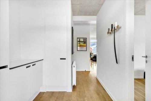 a kitchen with white walls and a refrigerator at Beautiful harbor view apartment in Hvide Sande