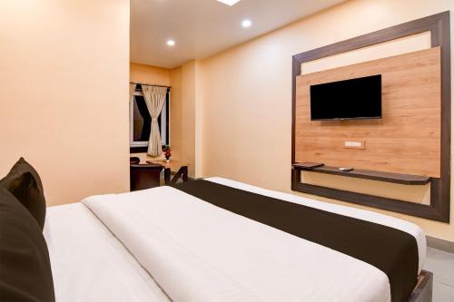 a bedroom with a bed and a flat screen tv at Super Townhouse OAK Bulbuli Neer in Kolkata