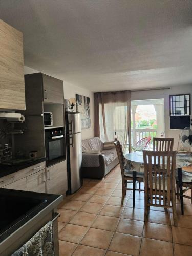 une cuisine et une salle à manger avec une table et des chaises dans l'établissement Résidence Pointe Vermeille - 2 Pièces pour 4 Personnes 321, au Barcarès
