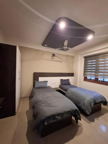 two beds in a bedroom with a sloped ceiling at Oakhaven Apartments near Mico Layout in Bengaluru