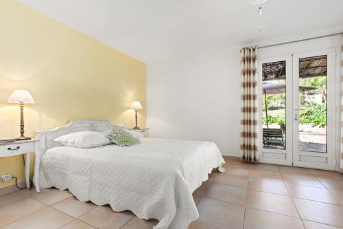 une chambre blanche avec un lit et une fenêtre dans l'établissement Parenthèse provençale avec 3 suites, piscine, calme, à Gattières
