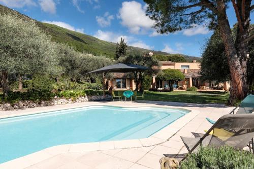 une piscine dans une cour avec une maison dans l'établissement Parenthèse provençale avec 3 suites, piscine, calme, à Gattières
