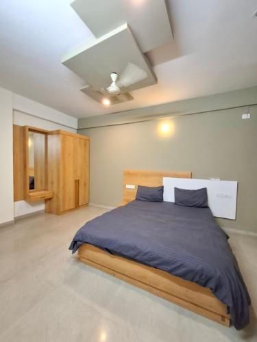 a bedroom with a bed with blue sheets and a ceiling at Oakhaven Apartments near Mico Layout in Bengaluru