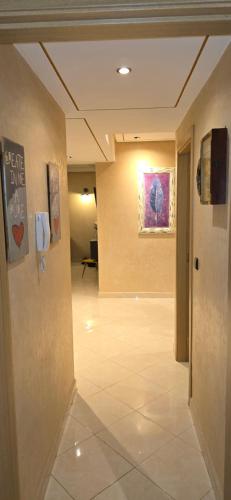 a hallway with a tile floor and a painting on the wall at Résidence achakkar hill in Jbila