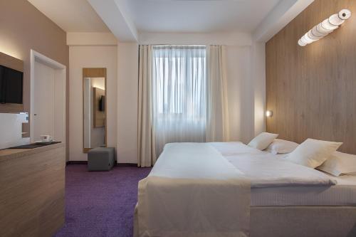 Un pat sau paturi într-o cameră la City Park Hotel