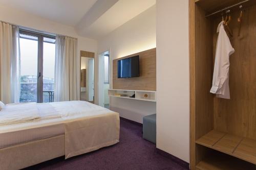 a hotel room with a bed and a tv at City Park Hotel in Skopje