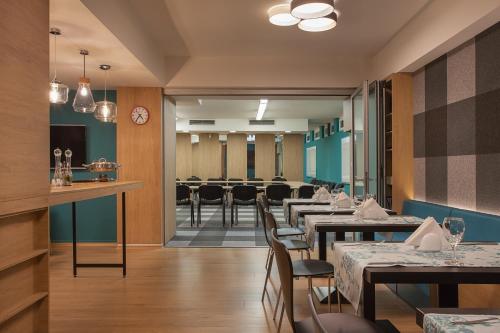 a restaurant with tables and chairs and a waiting room at City Park Hotel in Skopje