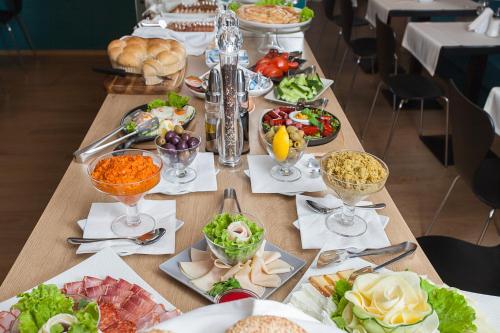 a long table with many plates of food on it at City Park Hotel in Skopje