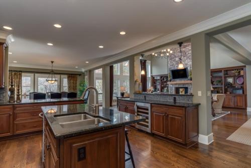 a large kitchen with wooden cabinets and a sink at Grand Family Retreat 8Br With Stunning Golf Views in Mill Spring