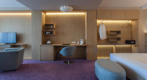 a hotel room with a bed and a desk and chair at City Park Hotel in Skopje