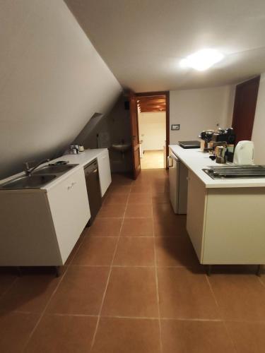 a kitchen with white appliances and a tile floor at Velocipéd Vendégház in Balatonudvari