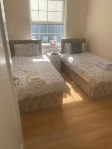 a bedroom with two beds and a window at O'Brien's Apt no breakfast in Galway