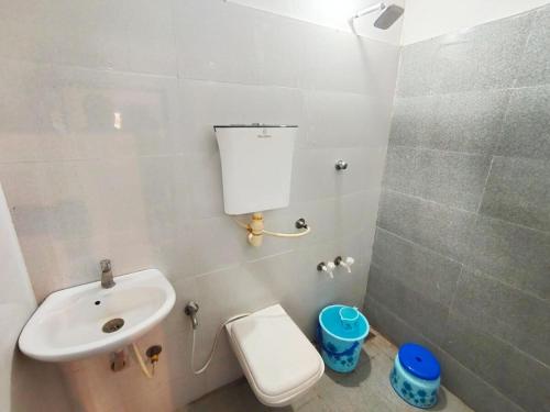 a white bathroom with a sink and a toilet at The Heaven - Farms & Resorts in Ānakhol
