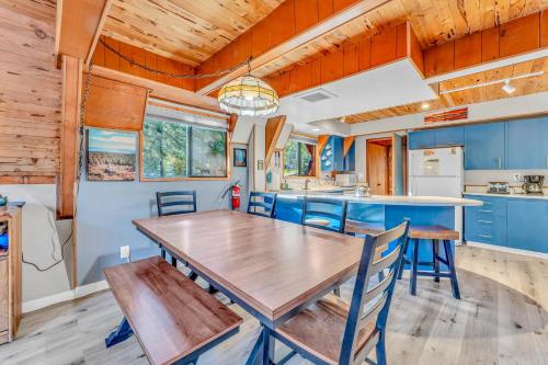 a dining room and kitchen with a wooden table and chairs at 3BR Tahoe Cabin in the Trees with Hot Tub in Carnelian Bay