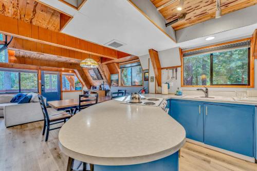 a kitchen and living room with a table and chairs at 3BR Tahoe Cabin in the Trees with Hot Tub in Carnelian Bay