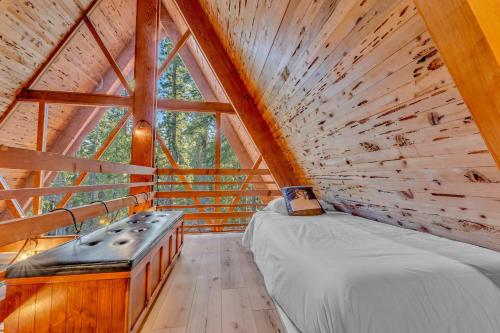 a bed in a room with a large window at 3BR Tahoe Cabin in the Trees with Hot Tub in Carnelian Bay