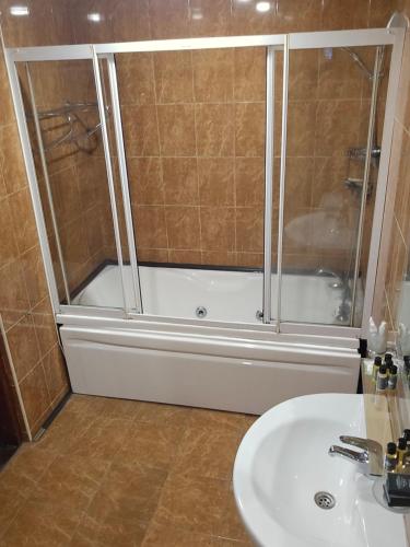 a bathroom with a shower and a sink and a tub at Ritsa Boutique Hotel in Batumi