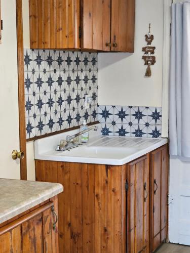 a kitchen with a sink and blue and white tiles at Castaways Cottage on Croton Pond #5 in Newaygo