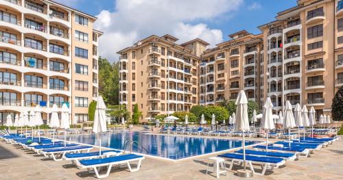 a pool with chairs and umbrellas in front of buildings at Hermann's Sea View Apartment - Bendita Mare in Varna City