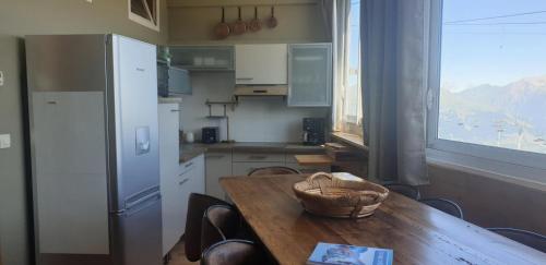 - une cuisine avec une table en bois et un bol dans l'établissement Résidence Choucas - 3 Pièces pour 7 Personnes 244, à La Plagne Tarentaise